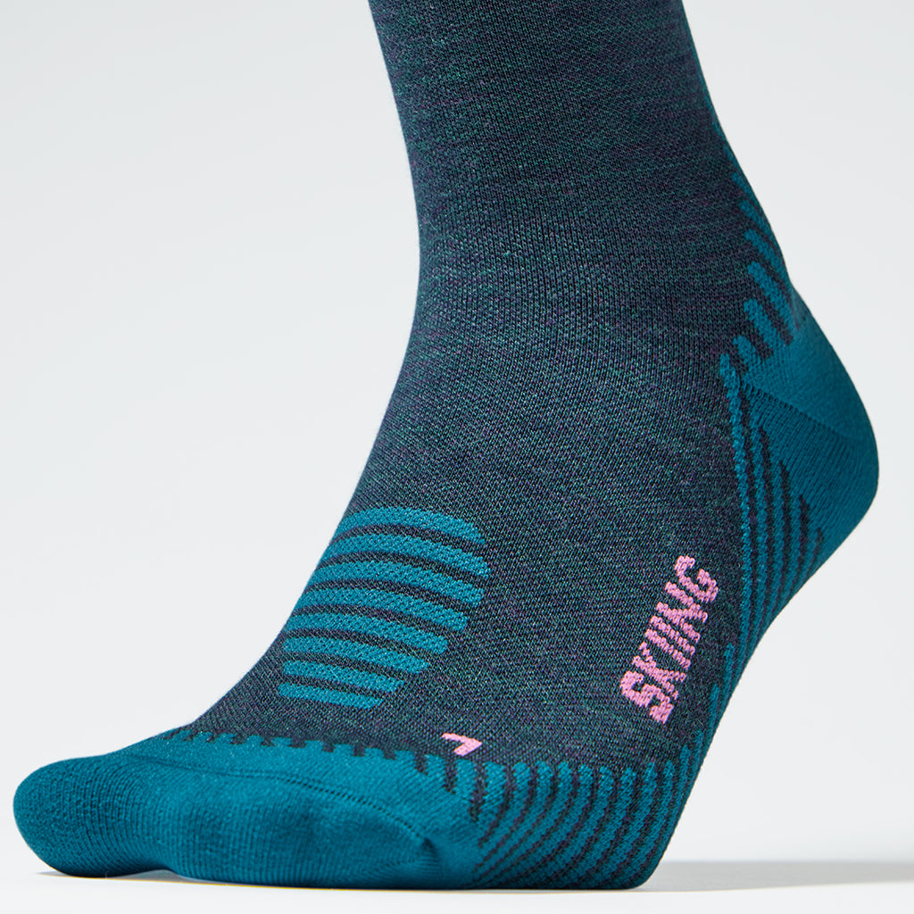 Close up of a teal compression sock with pink details.