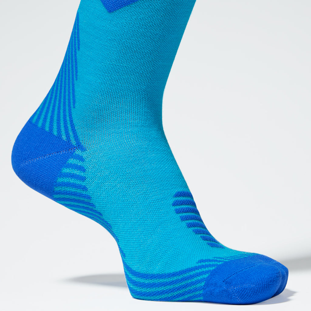 Close up of a turquoise compression sock with cobalt details.