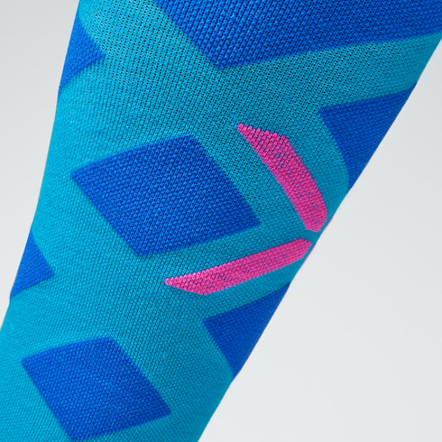 Close up a turquoise and cobalt compression sock with a pink detail.