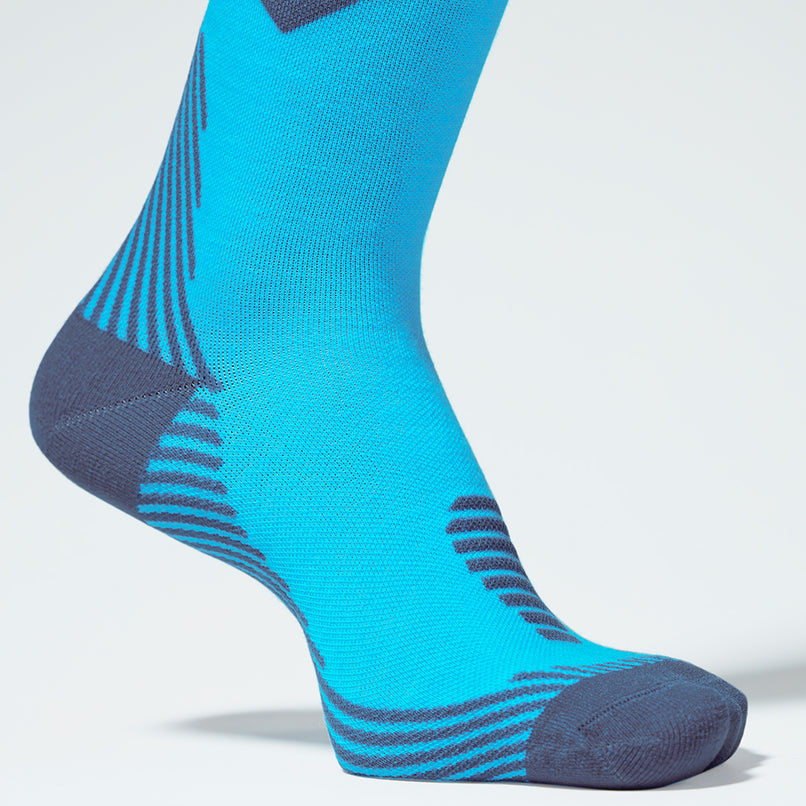 Zoomed in view of a turquoise knee high compression sock with pink details.