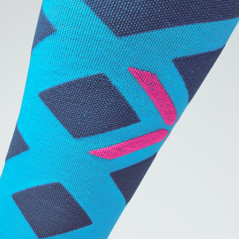 Zoomed in view of a turquoise knee high compression sock with pink details.