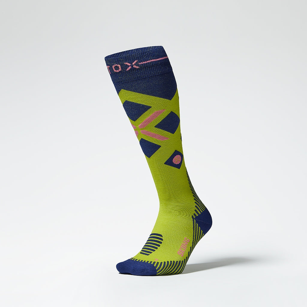 Front view of a yellow compression skiing socks with pink details.