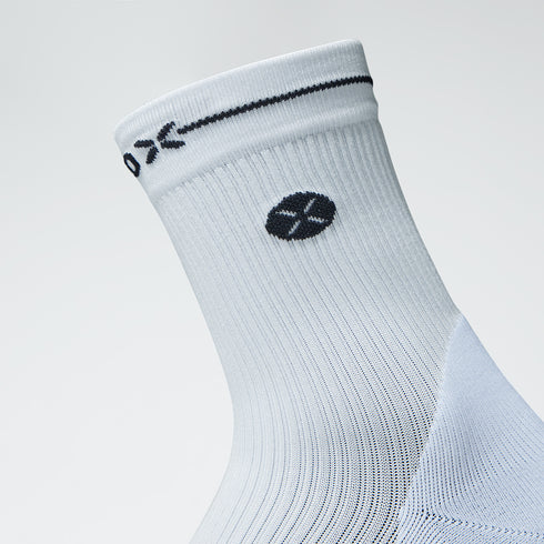 Close up of an ankle high compression sock in white with a black logo. 