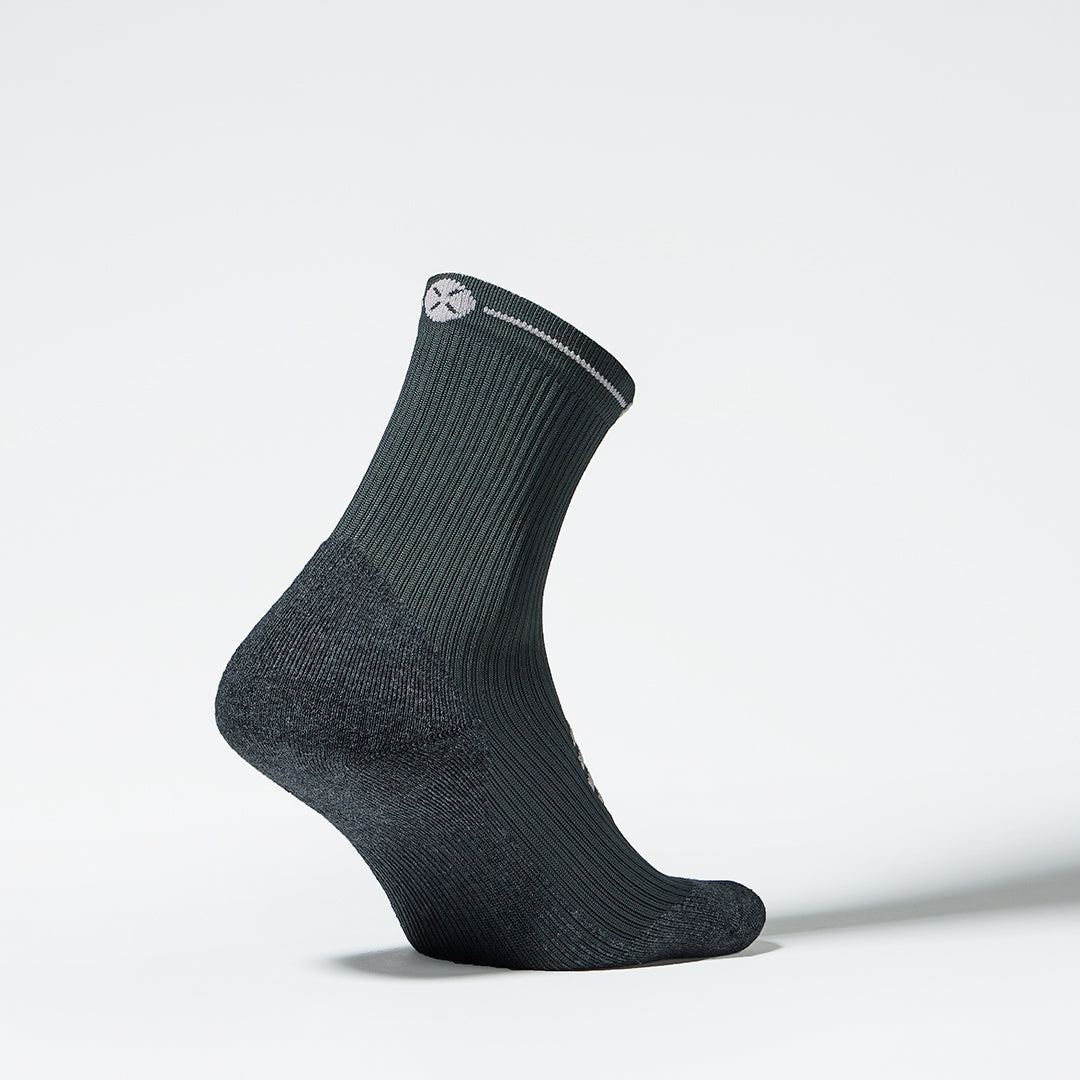 Side view of a dark grey ankle high compression sock. 