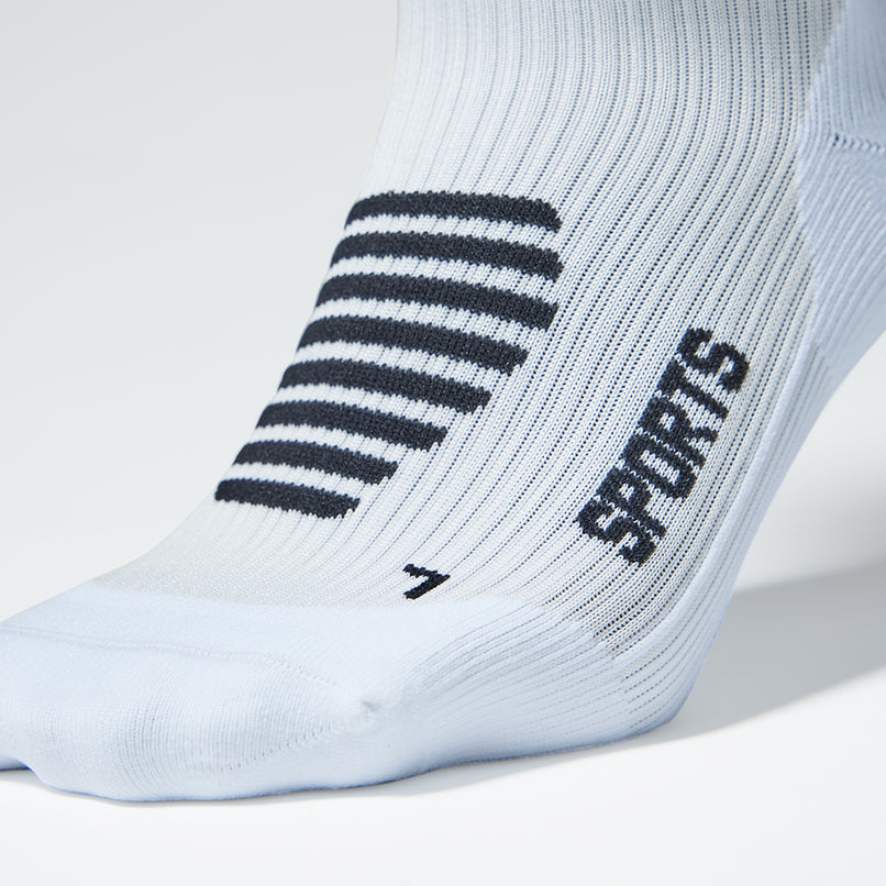 Close up of a white compression sock with black accents. 