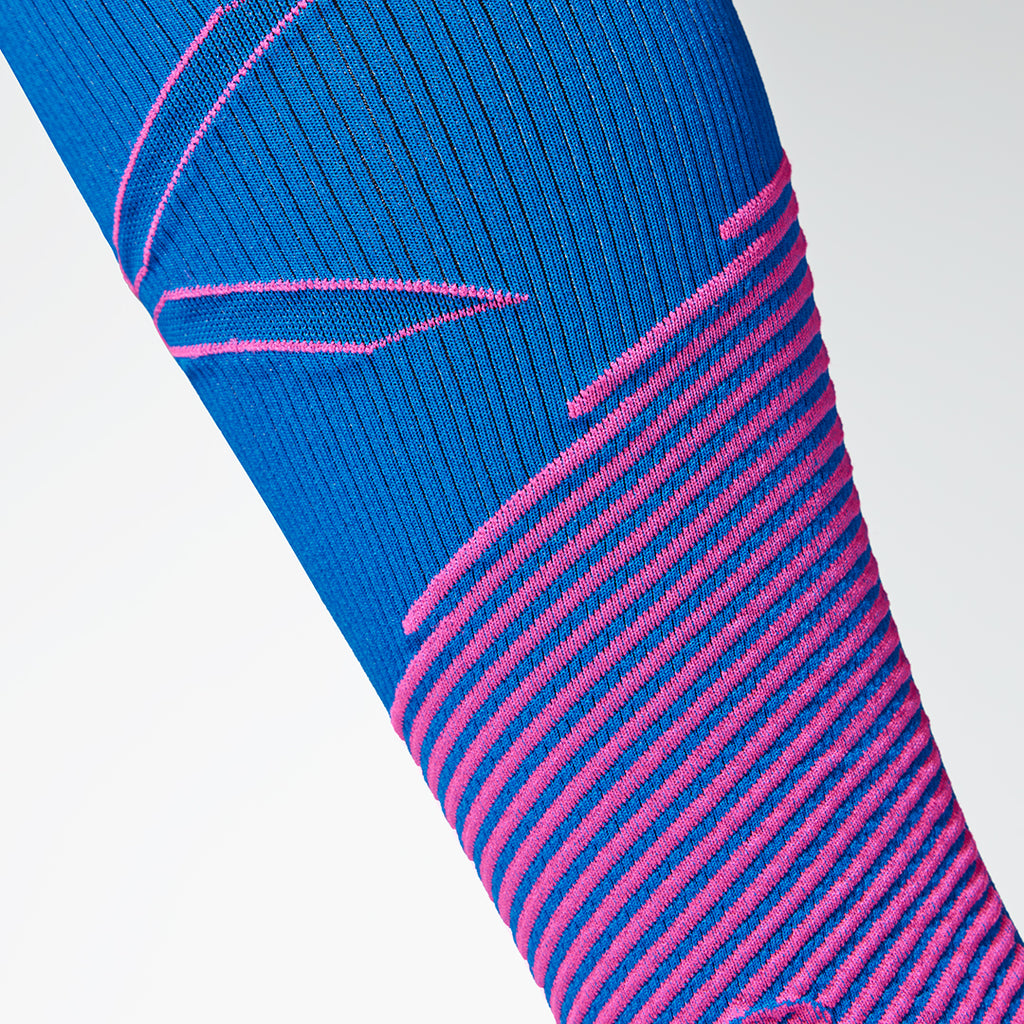 Detailed view of a blue compression calf sleeve with pink details. 