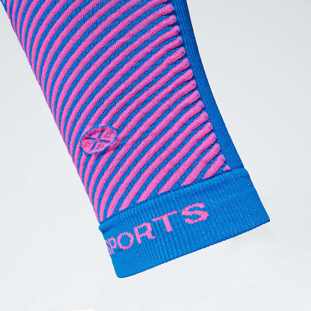 Detailed view of a blue compression calf sleeve with pink details. 