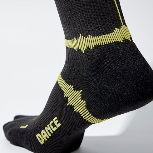 Close up of a black sock with yellow details. Heart beat lines and the word dance.