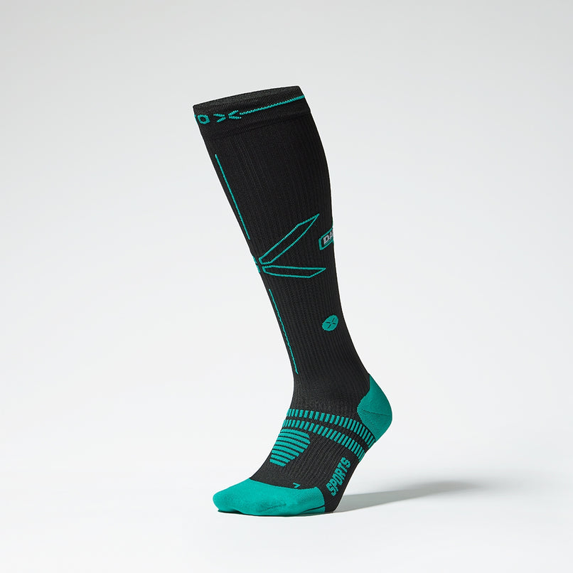 Front view of a black compression sock with blue green details.