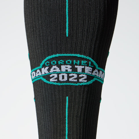 Detailed view of a black compression sock with Dakar 2022 logo.