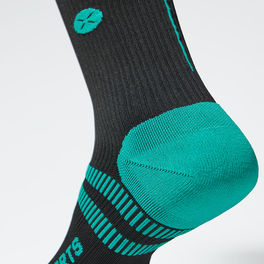 Detailed view of a black compression sock with blue green details.