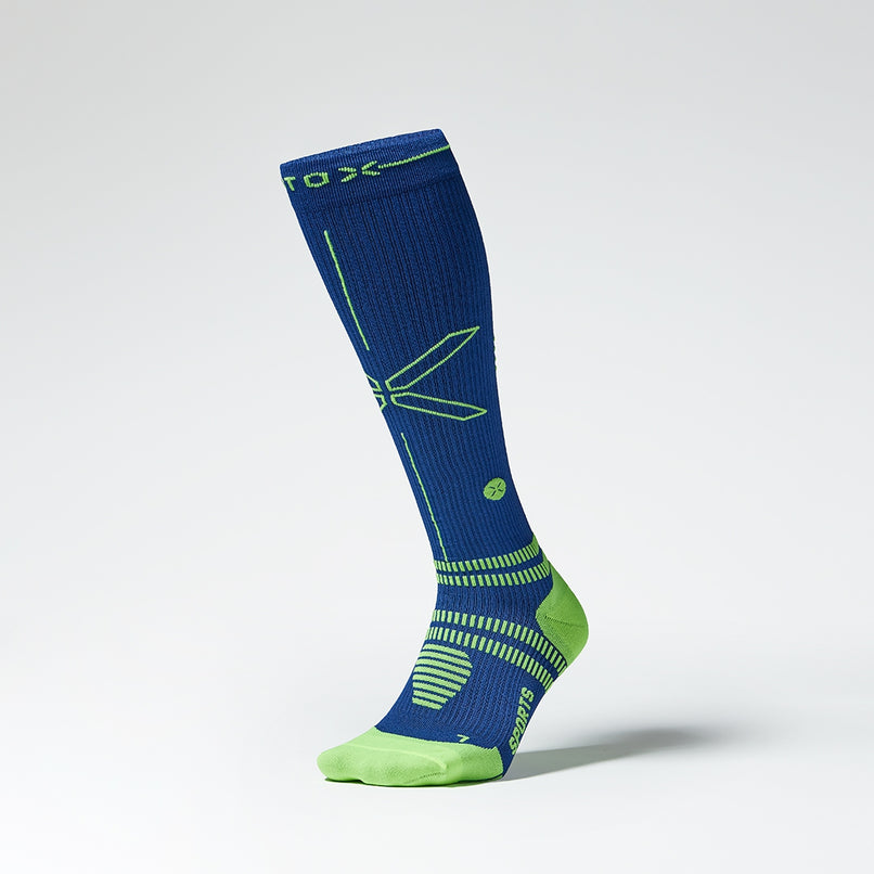 A knee high compression sock in dark blue with yellow details from the front.