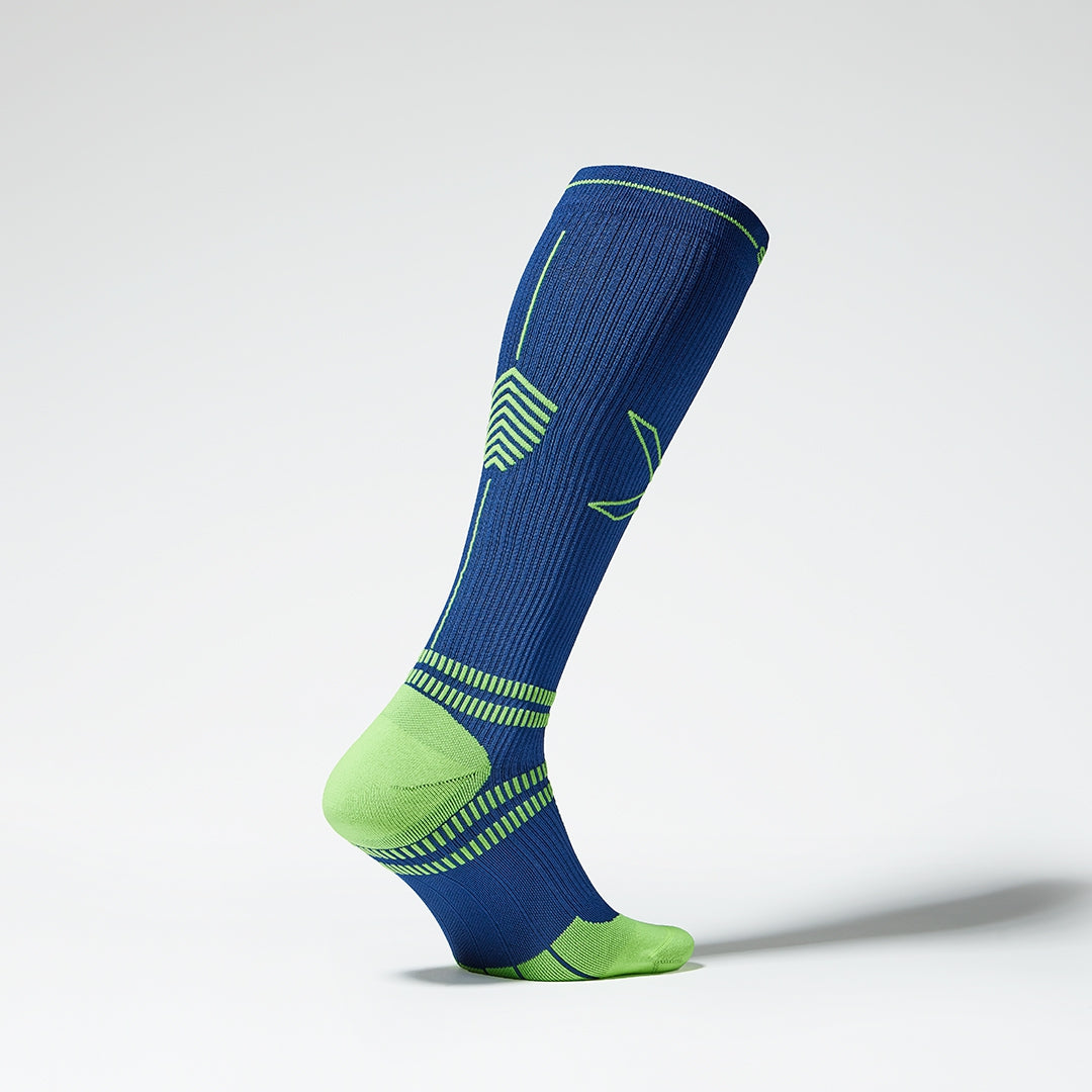 Side view of a knee high compression sock in dark blue and yellow.