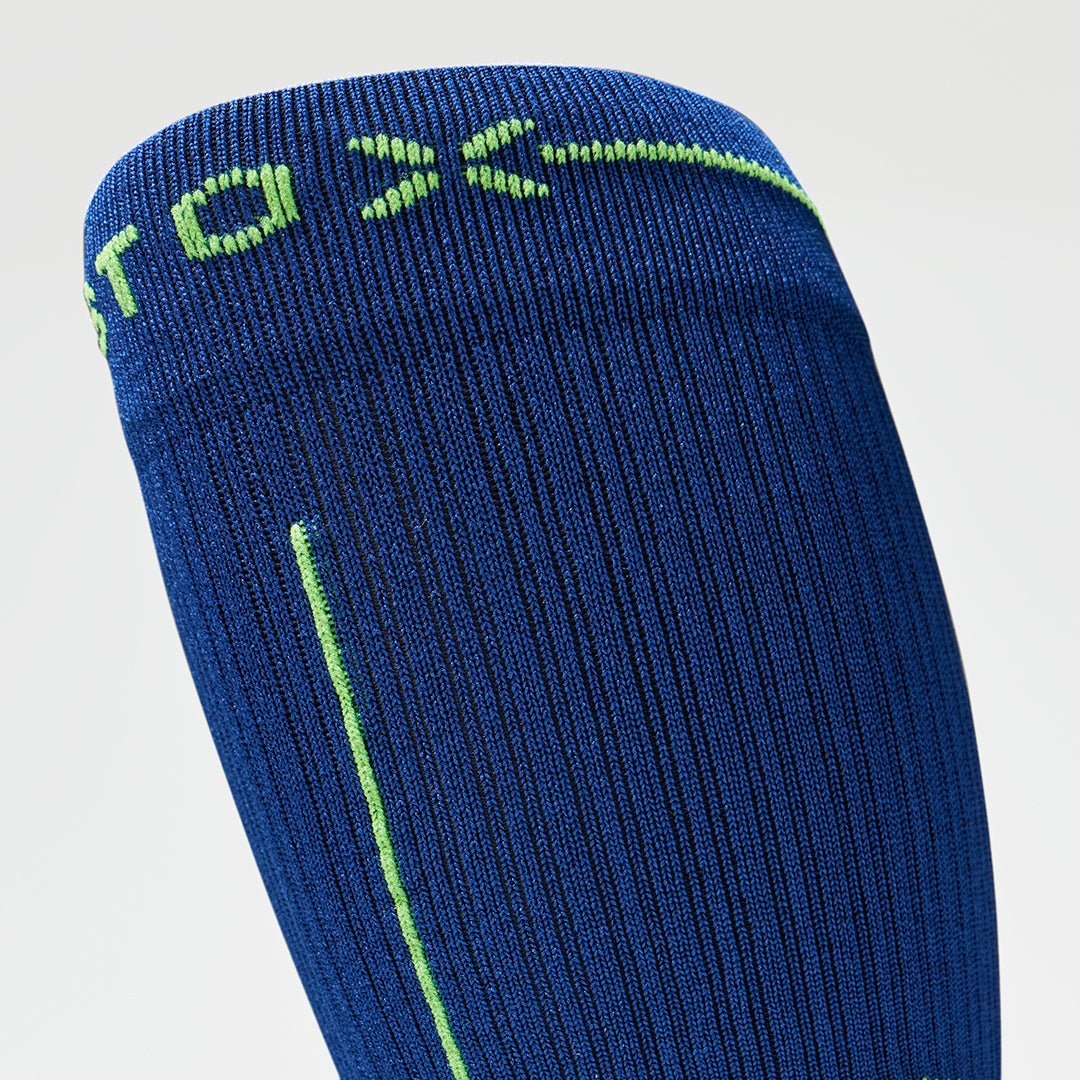 Close up of a dark blue compression sock with a yellow logo.