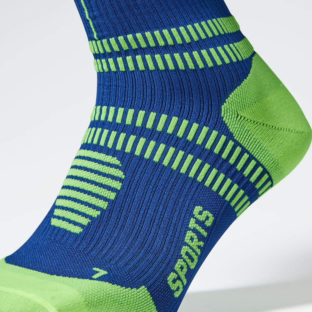 Close up of a blue compression sock with a yellow heel and details. 