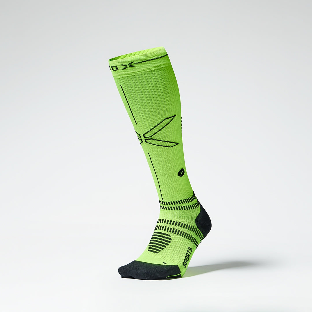 Front view of a fluo yellow compression sock with black details.