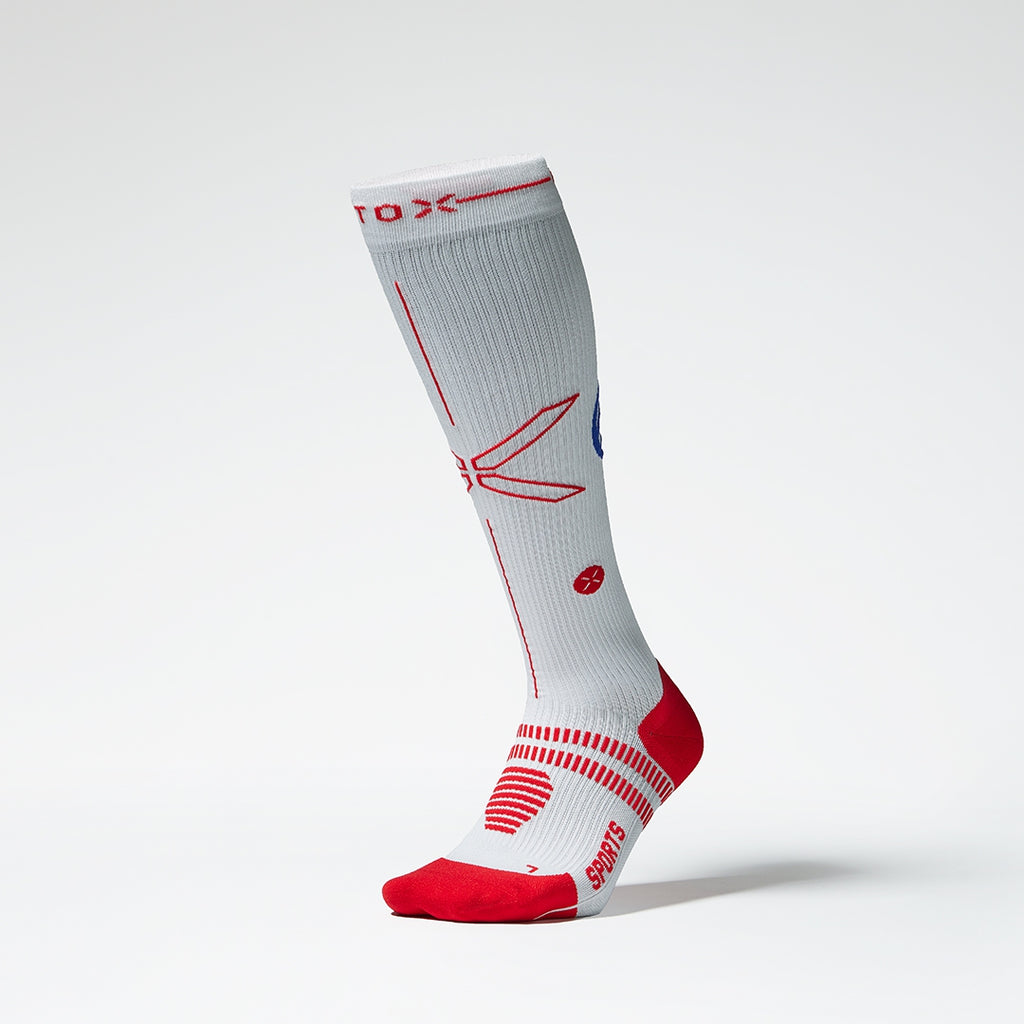 Front view of a white compression sock with red details.