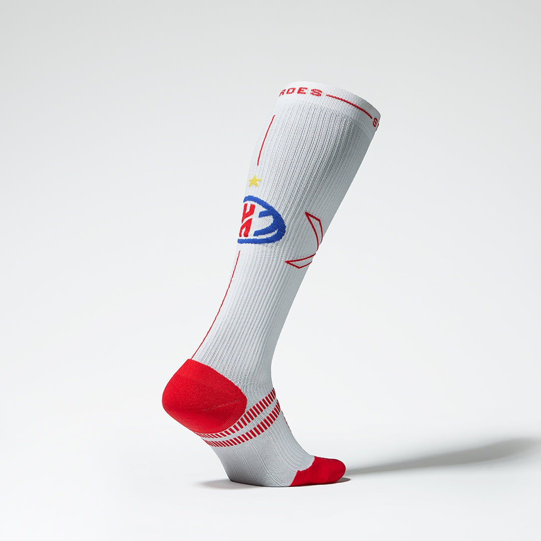 Side view of a white compression sock with red details.