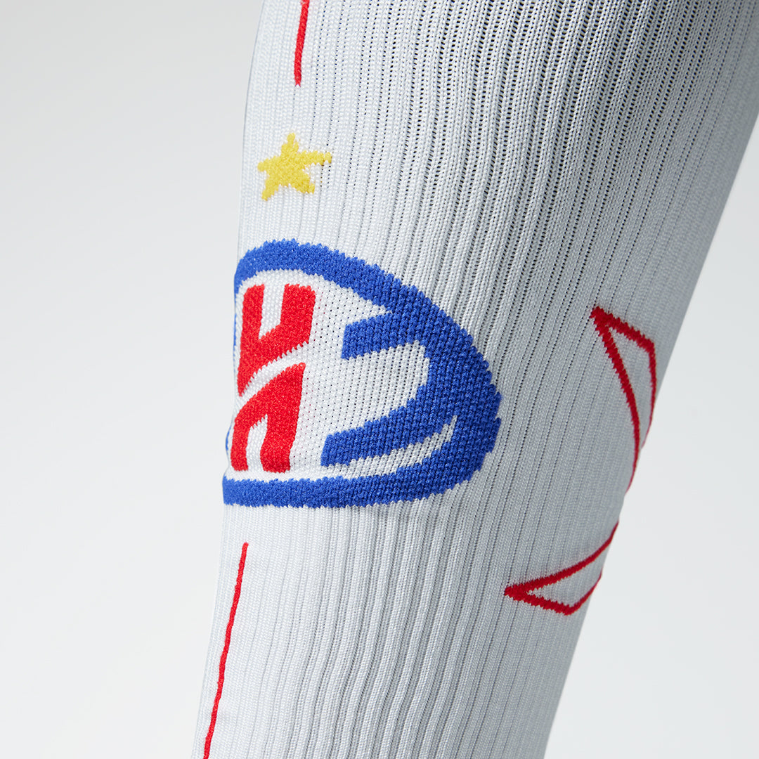 Close up of a white compression sock with a Heroes logo in red and blue.