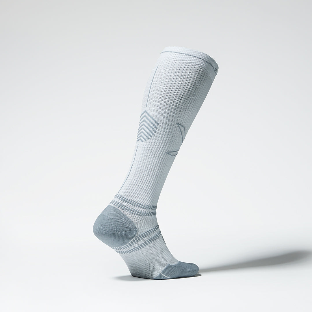 Side view of a knee high compression sock in white with grey details.