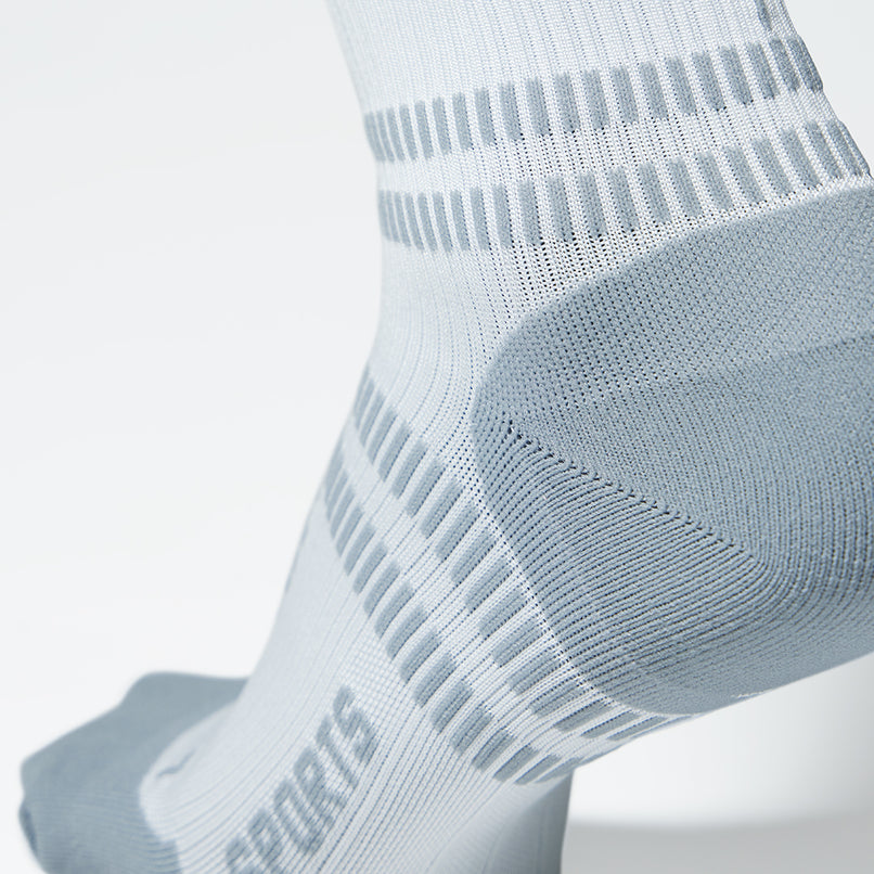 Close up of white compression sock with grey heel. 
