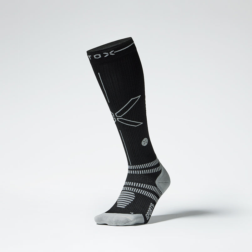 Front picture of a black compression sock with a grey detail.