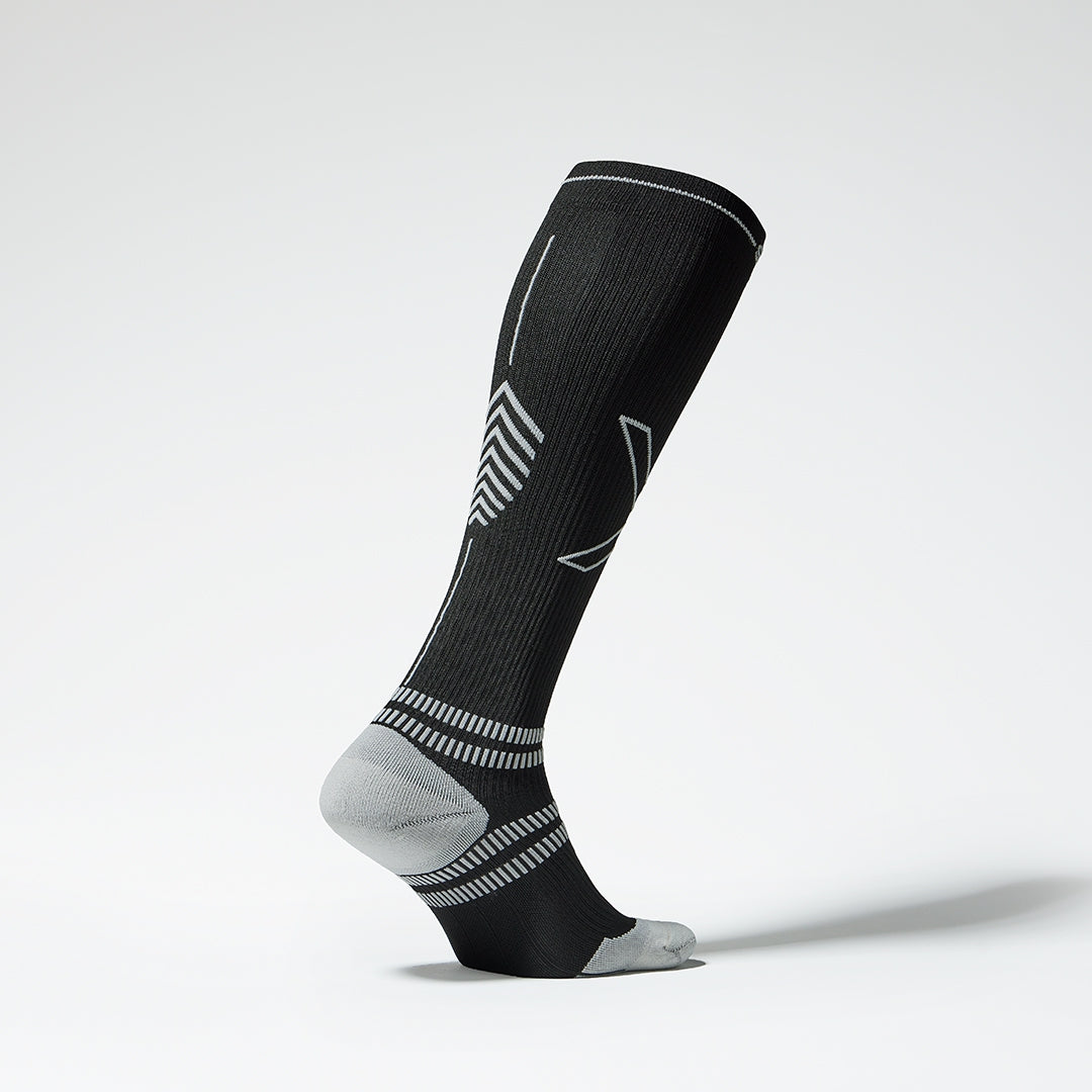The side of a black compression sock with grey accents. 