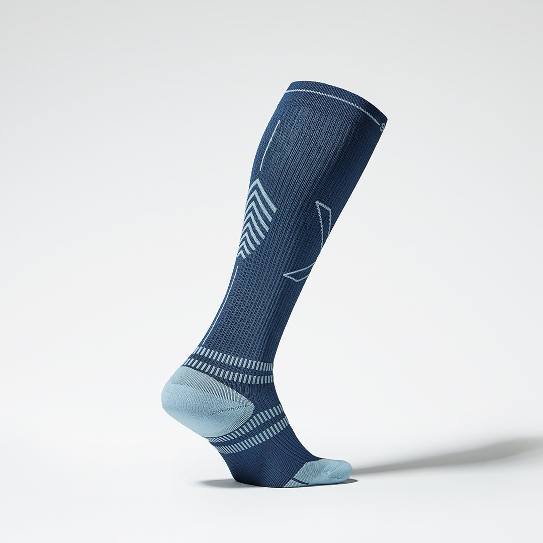 The side view of a high compression sock in blue with grey details.