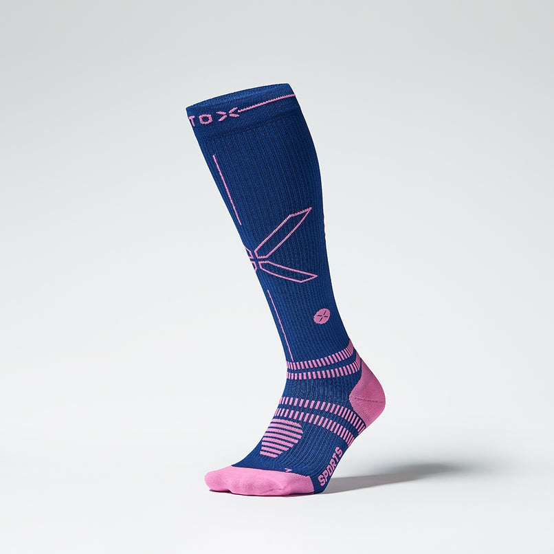 Front view of a knee high compression sock in dark blue with pink accents. 