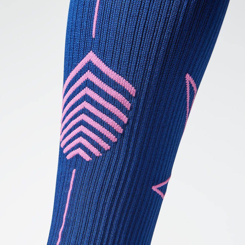 Close up of a compression sock in dark blue with pink accents. 