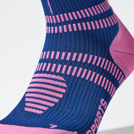 Close up of a dark blue compression sock with a pink coloured logo. 