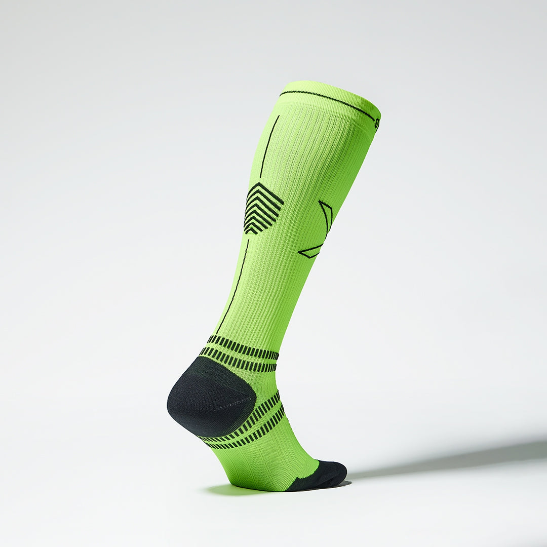 Side view of a fluor yellow compression sock with black details.