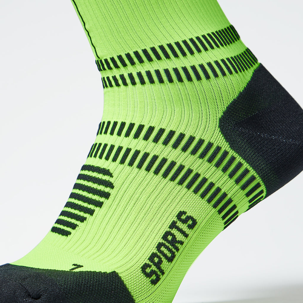 Detailed view of a fluo yellow compression sock with black details.