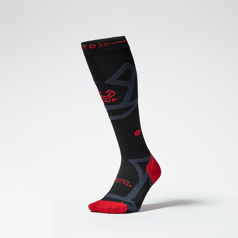 Front view of a knee high compression sock with red and anthracite grey details. 