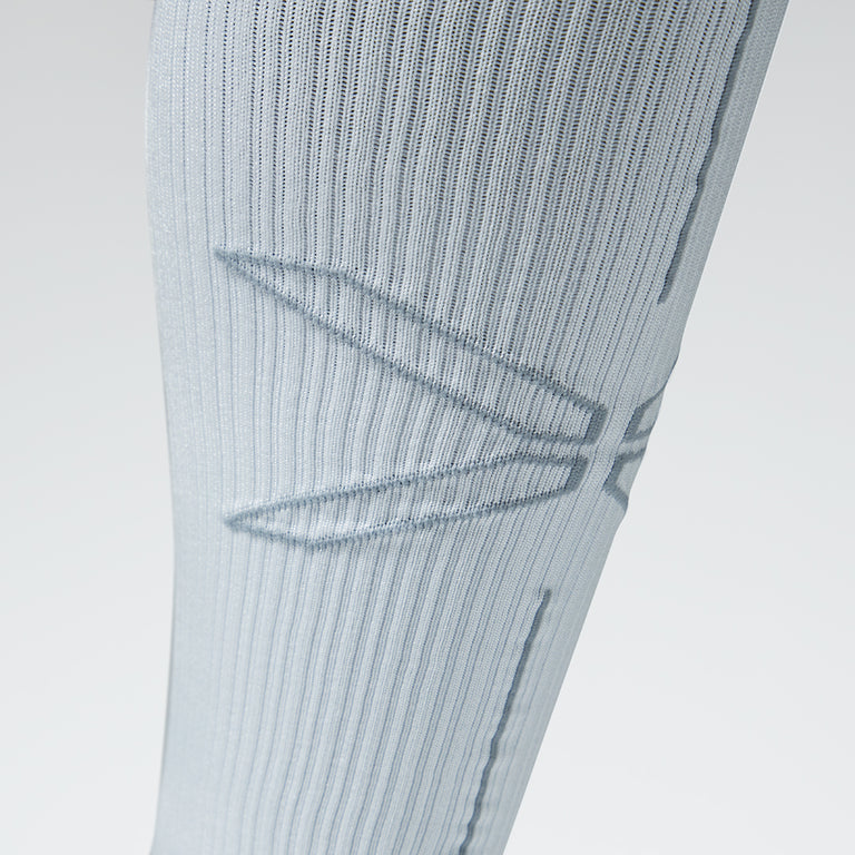 Close up of a white compression sock with a grey logo.