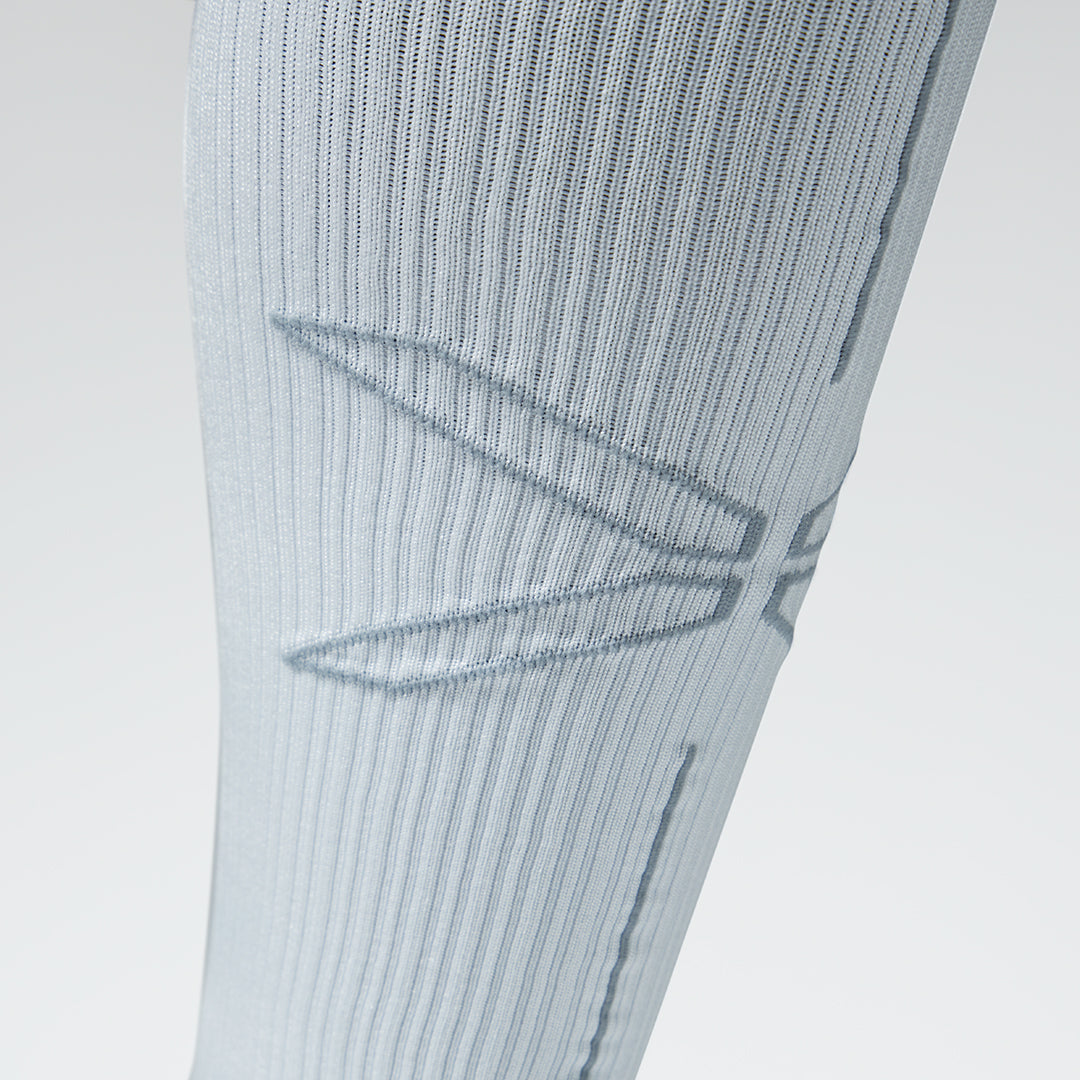 Close up of a white compression sock with a grey logo.