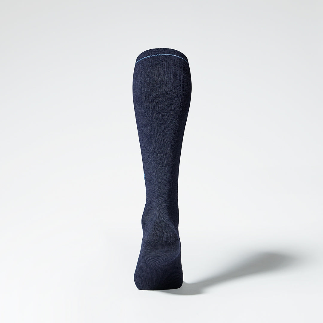 Back view of a blue knee high compression sock with blue details.