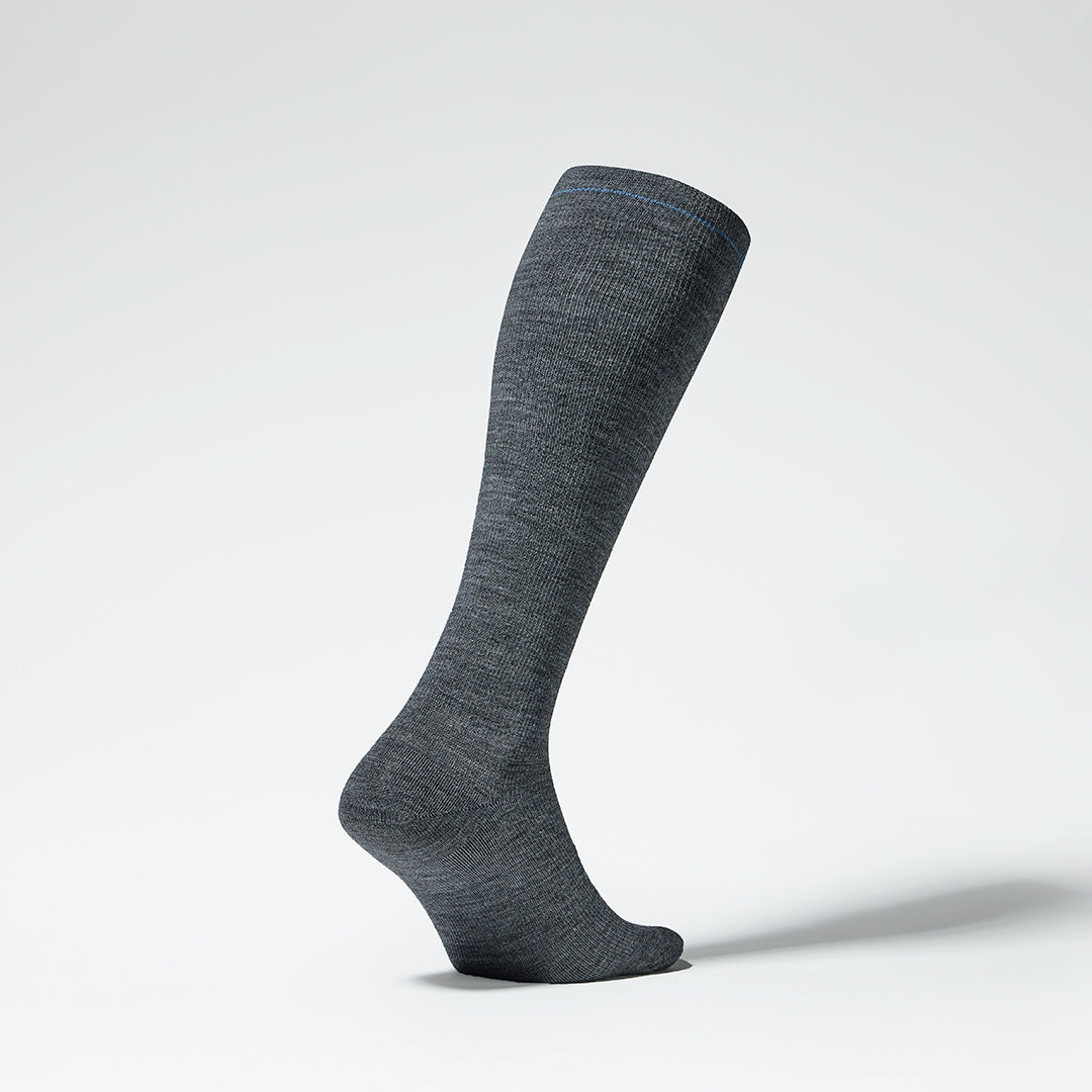 Side view of a grey knee high compression sock with blue details.
