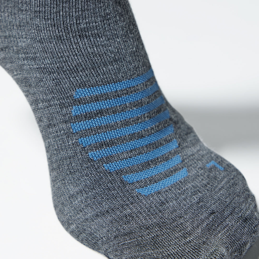 Detailed view of a grey knee high compression sock with blue details.