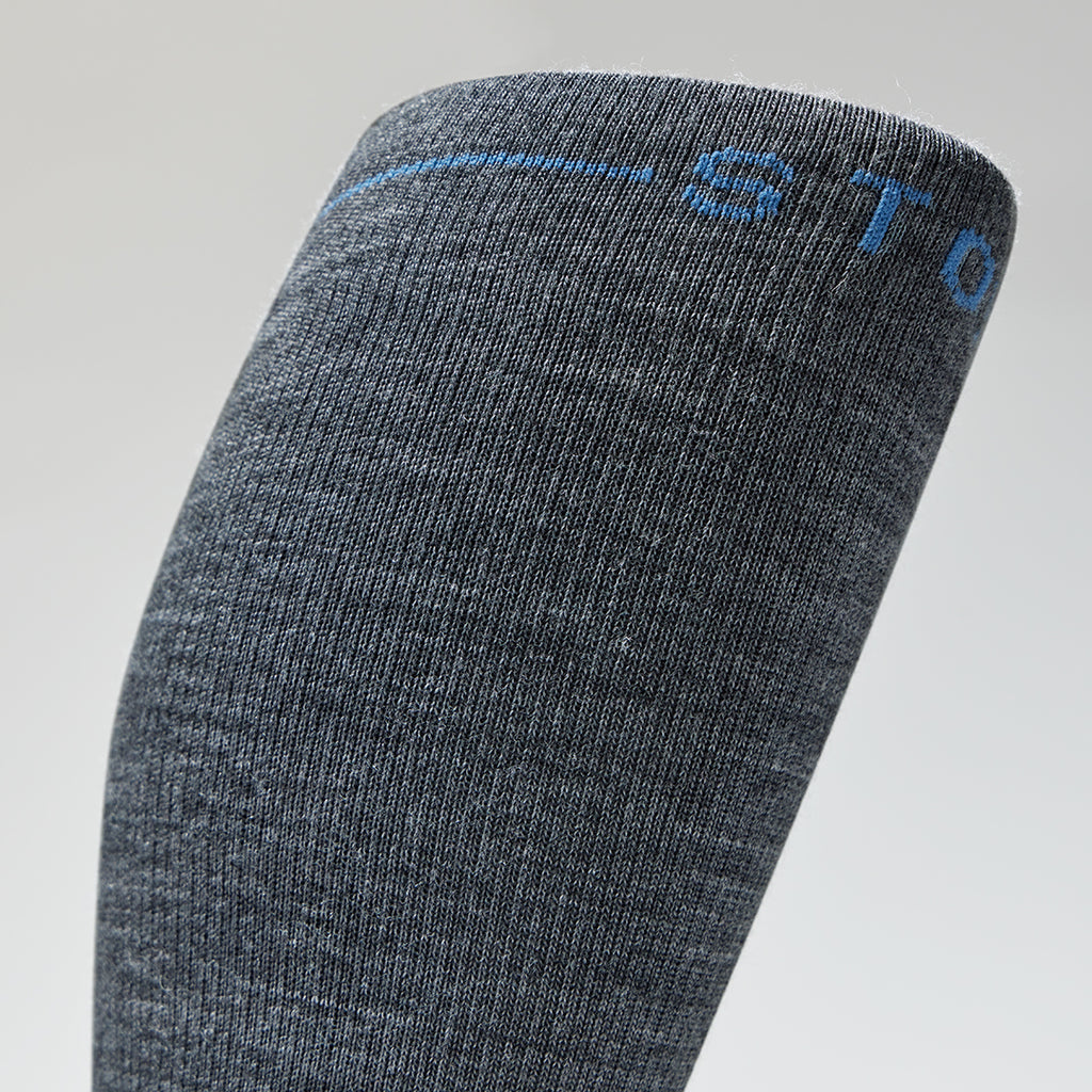 Detailed view of the top grey knee high compression sock with blue details.