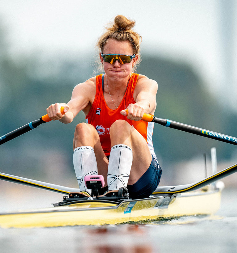 Woman rowing with intense focussed face. 