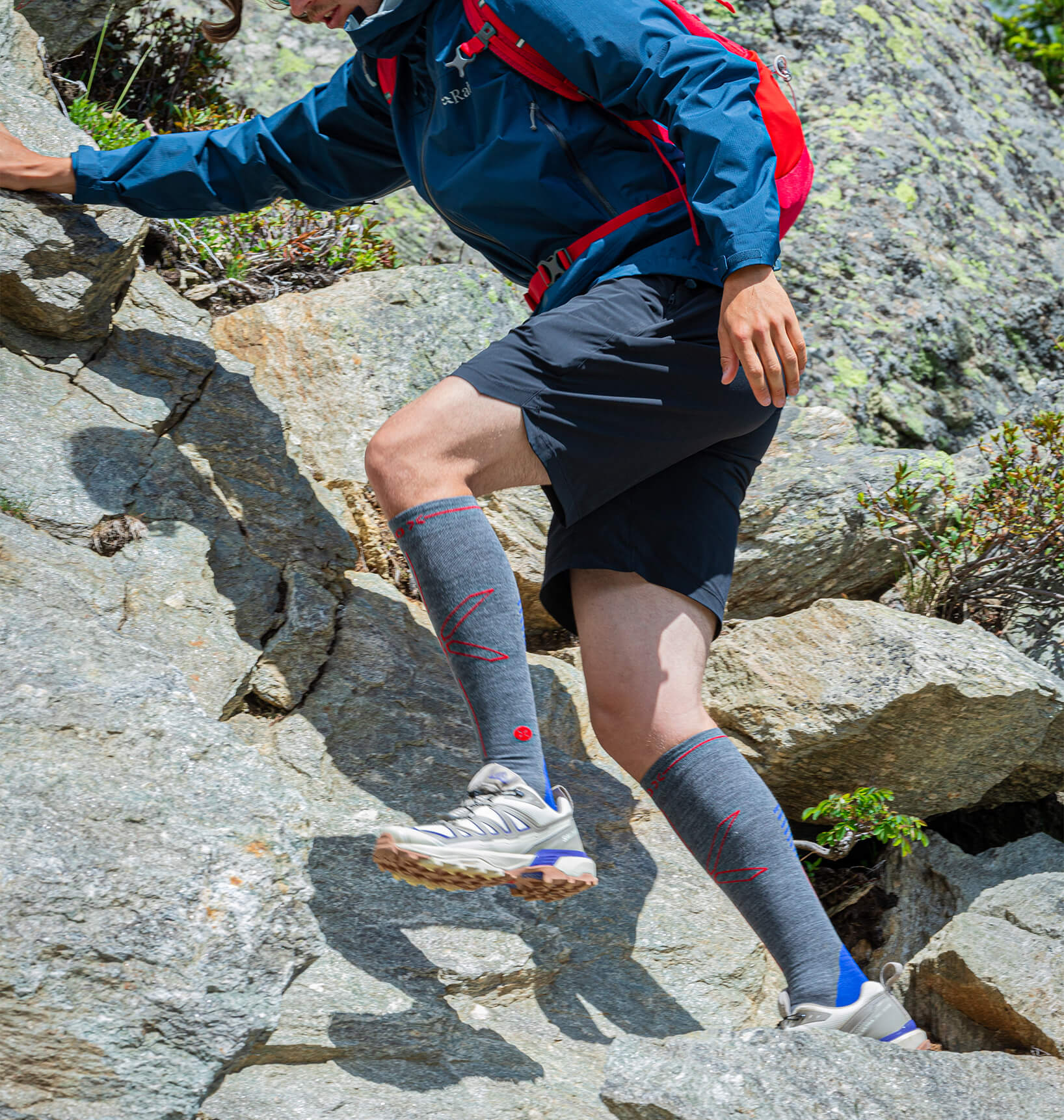 Men walking over rocks with high knee socks