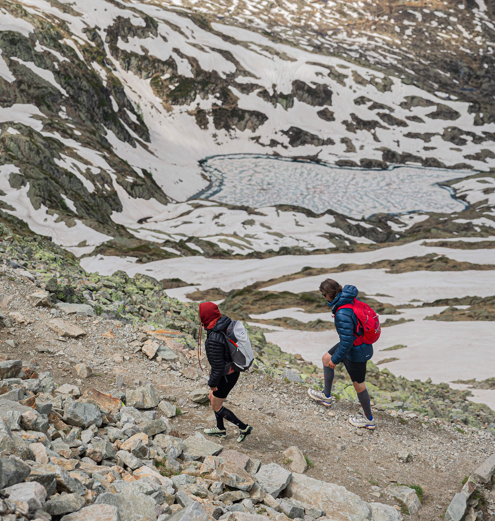 Couple walking over rocks in the mountains.