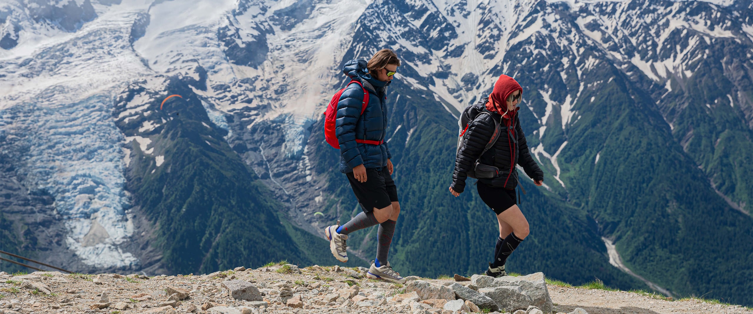 Couple walking over rocks in the mountains.