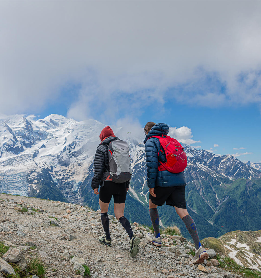 Couple walking over rocks in the mountains.