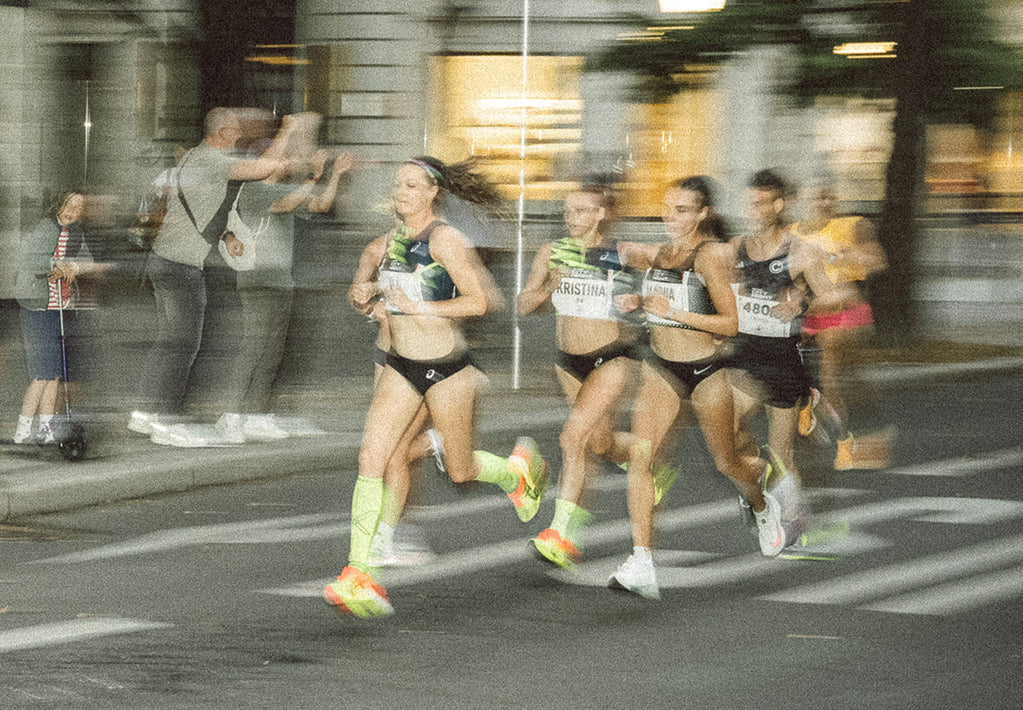 A group of people running wearing small shorts.