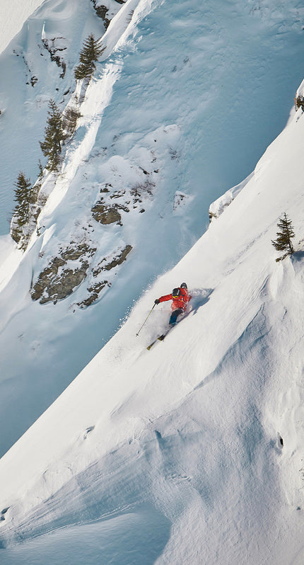 Person shot from afar skiing down offpiste.