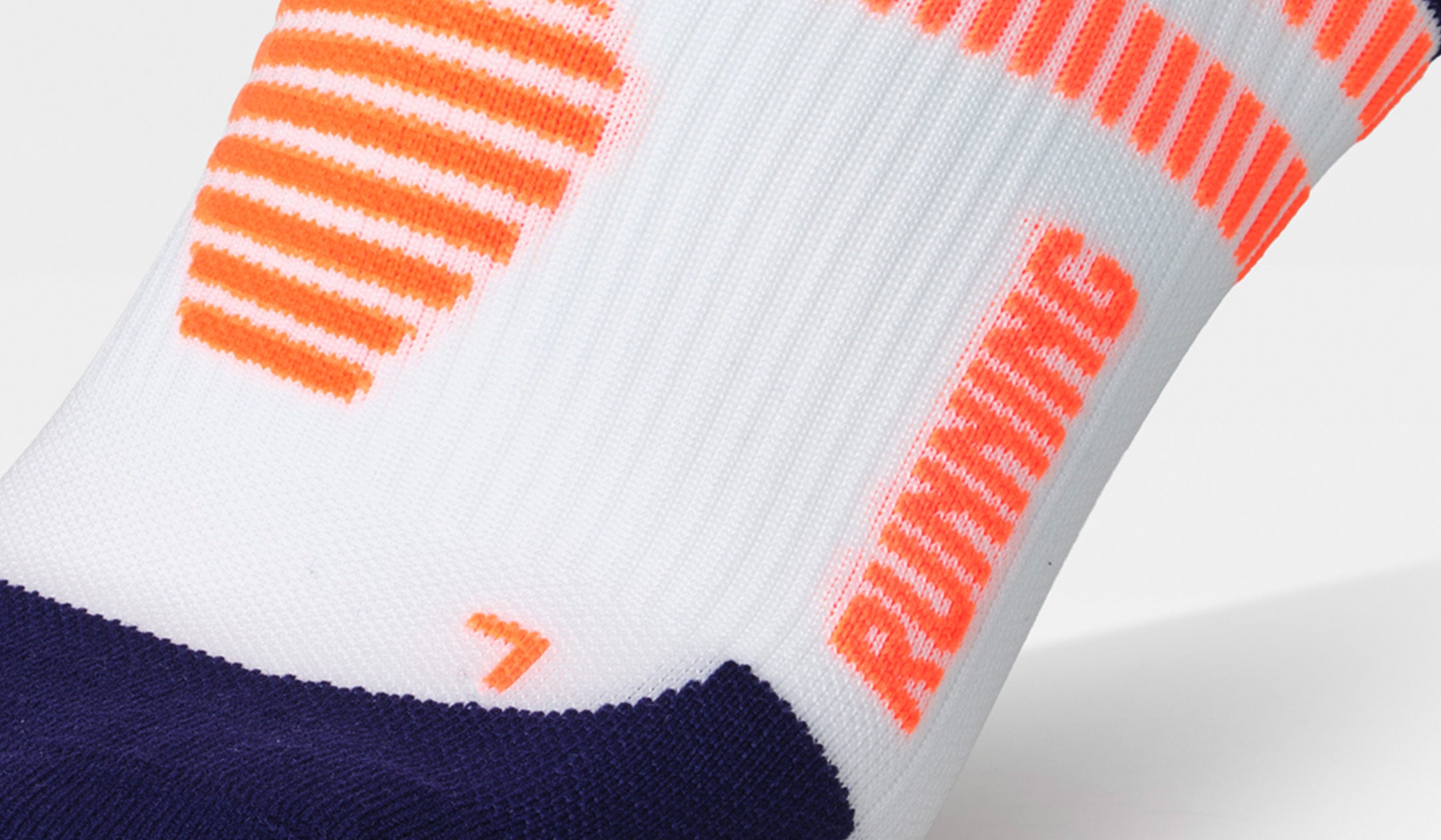 Close-up of a white sock with orange and blue accents.