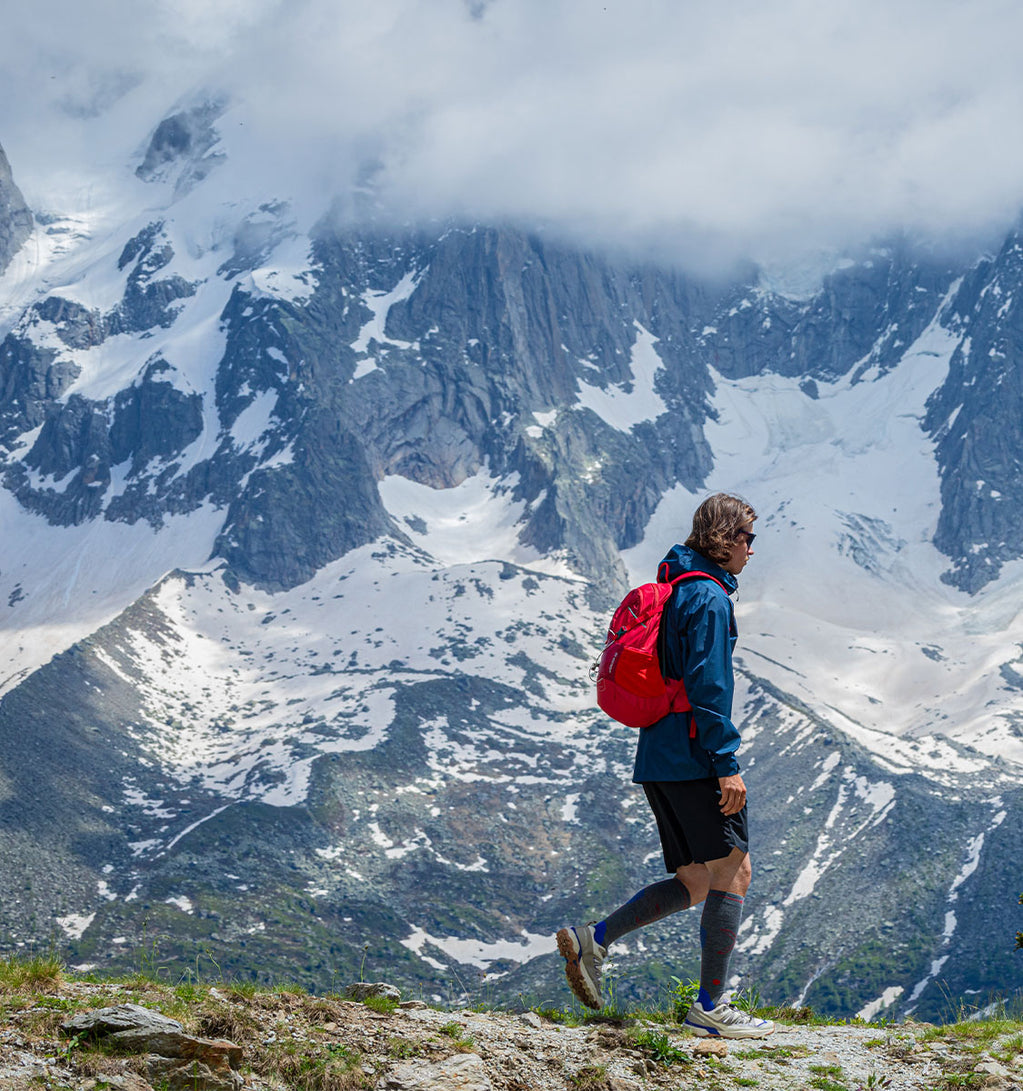 Men walking in the mountains with high knee socks.