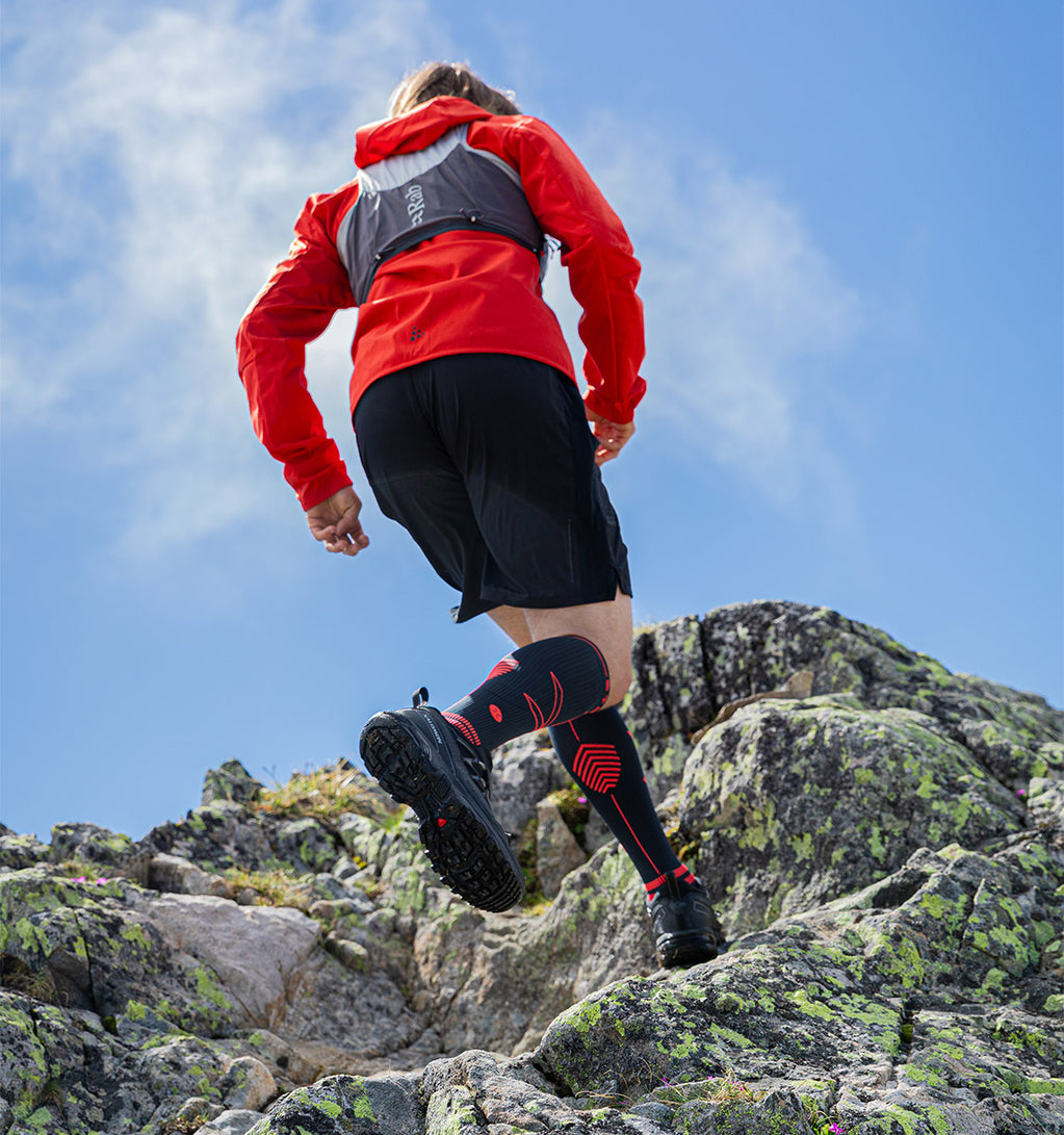 Men running in the mountains with high knee socks.